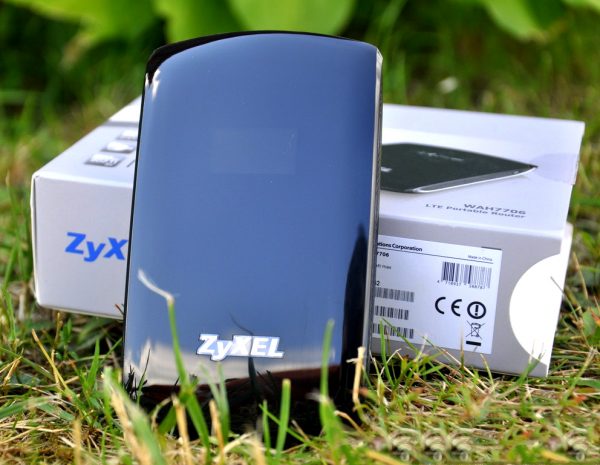 Мобильный роутер Zyxel WAH 7706 и упаковочная коробка на траве